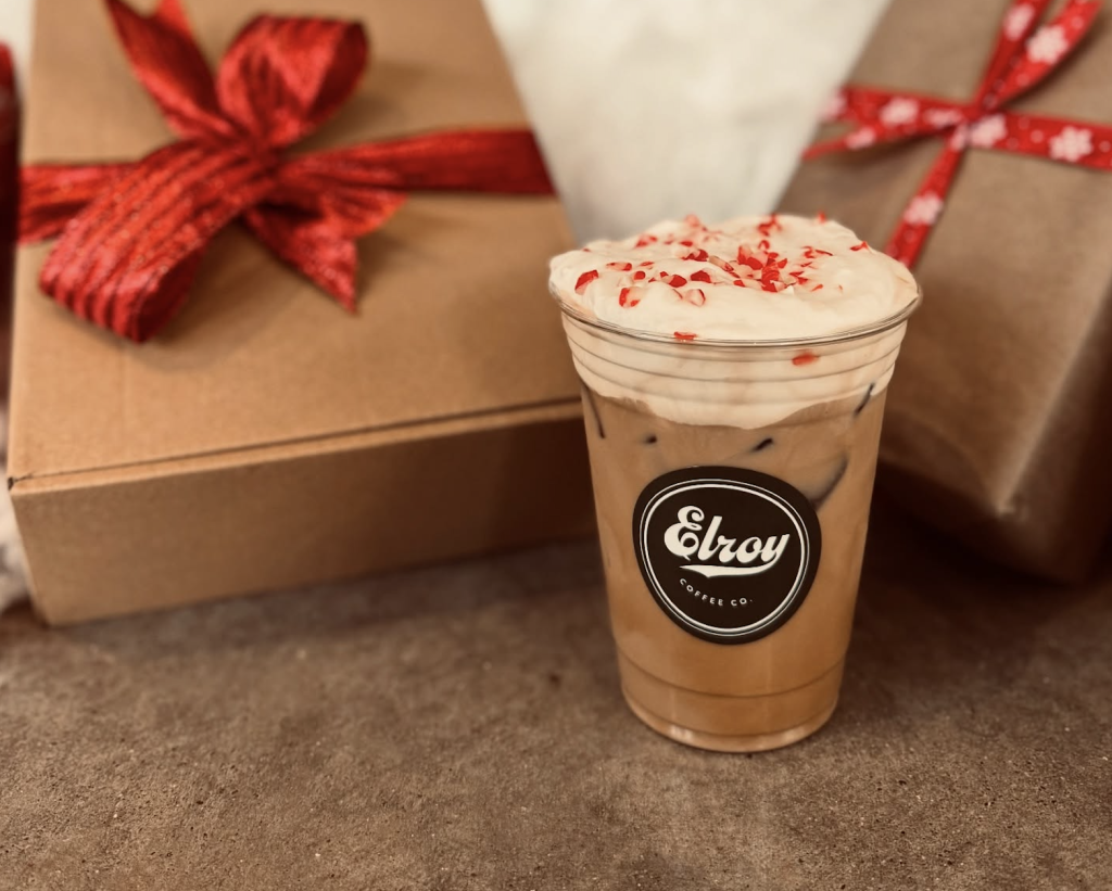 A festive coffee drink with whipped cream and red sprinkles in a clear plastic cup in Williamson County, Tennessee.