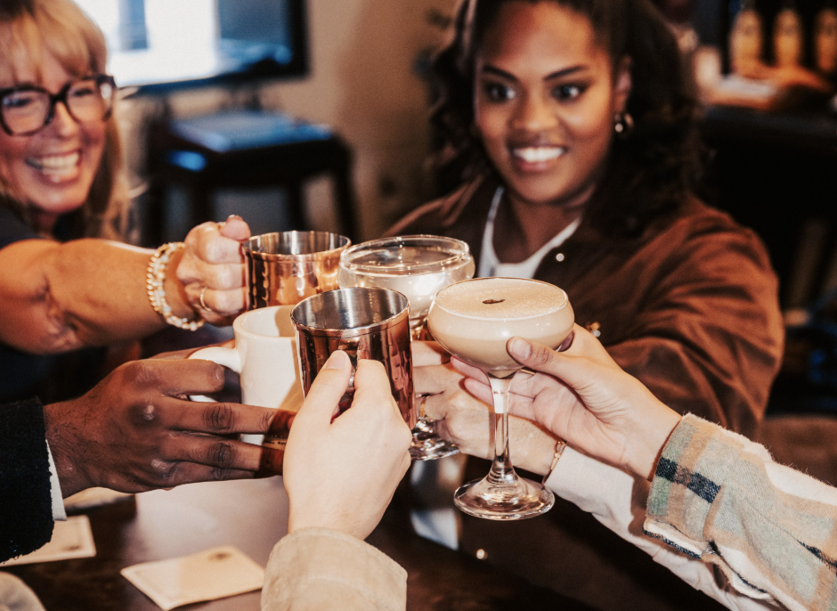 A group of people are raising their glasses in a toast at a bar or restaurant in Williamson County, Tennessee.