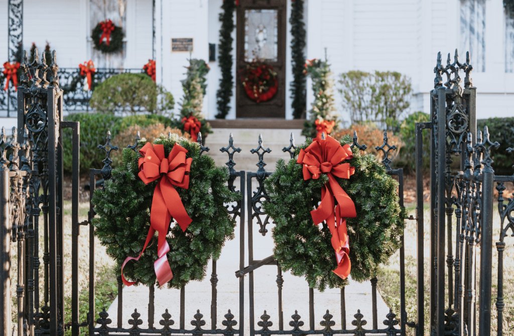 Christmas wreaths on gates of historic home