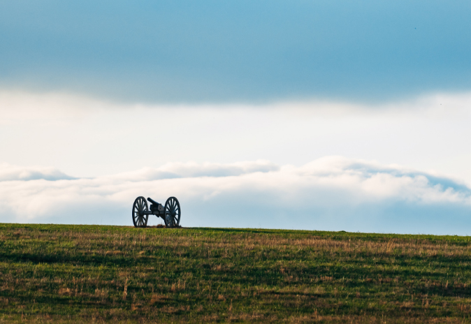 A lone cannon rests on a grassy hill, silhouetted against a cloudy sky in Williamson County, Tennessee.