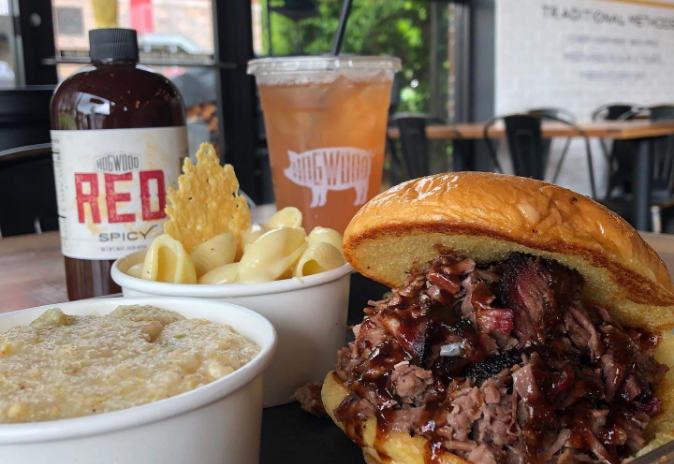 A hearty meal featuring a pulled pork sandwich, macaroni and cheese, and grits with hot sauce in Williamson County, Tennessee.