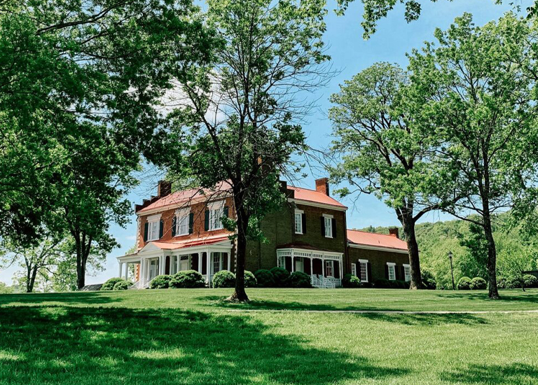 Brentwood A large red-roofed house with white columns and shutters is nestled among lush green trees in Williamson County, Tennessee.