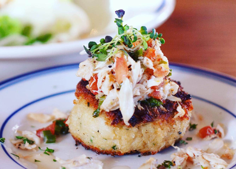 Brentwood A golden-brown crab cake topped with a colorful mix of crab meat, tomatoes, and herbs in Williamson County, Tennessee.