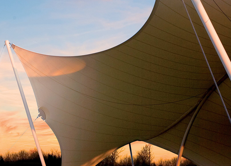 Brentwood A large, curved fabric structure with white poles creates a dramatic silhouette against a colorful sunset sky in Williamson County, Tennessee.
