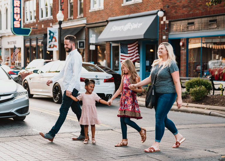 Franklin A family of four, including two young girls, walks hand-in-hand across a street in a small town in Williamson County, Tennessee.
