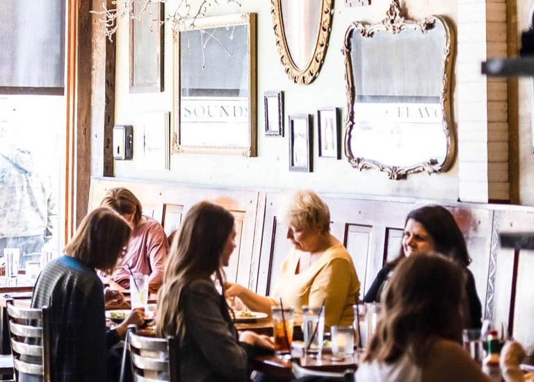 Franklin A group of women are gathered around a table in a cozy restaurant with vintage decor in Williamson County, Tennessee.