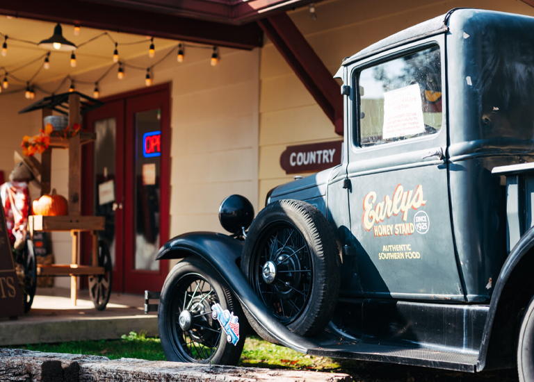 Spring Hill Vintage truck with 'Earl's Honey Stand' sign parked outside a country store with pumpkins in Williamson County, Tennessee.