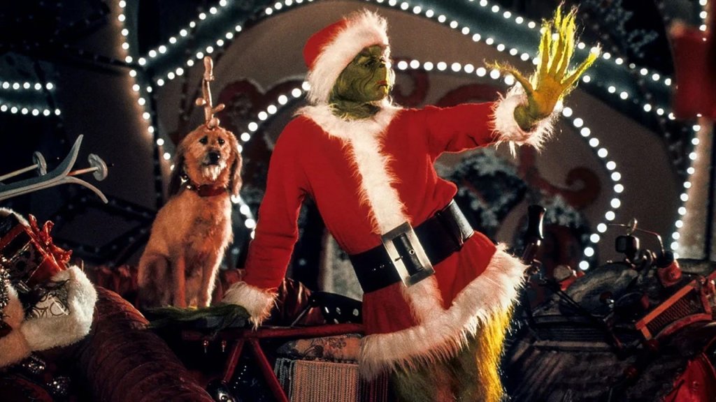 How the Grinch Stole Christmas (2000) The Grinch in a Santa suit gestures dramatically with his green hand, accompanied by Max the dog in Williamson County, Tennessee.