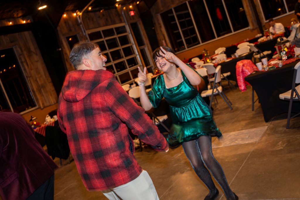 Deer Run's Daddy-Daughter Winter Ball A couple dances joyfully at a festive event in a rustic venue with string lights in Williamson County, Tennessee.