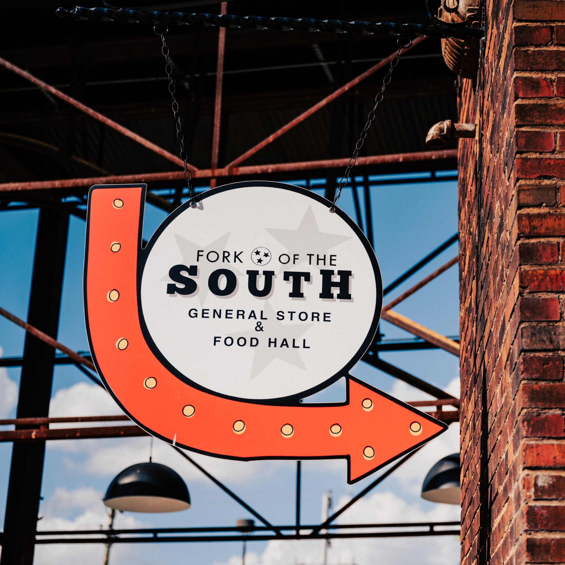 A large orange arrow points to a sign for a general store and food hall called 'South of the Fork' in Williamson County, Tennessee.