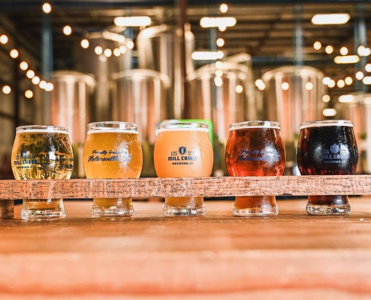 Five glasses of beer from Mill Creek Brewing Company, showcasing a variety of colors and styles in Williamson County, Tennessee.