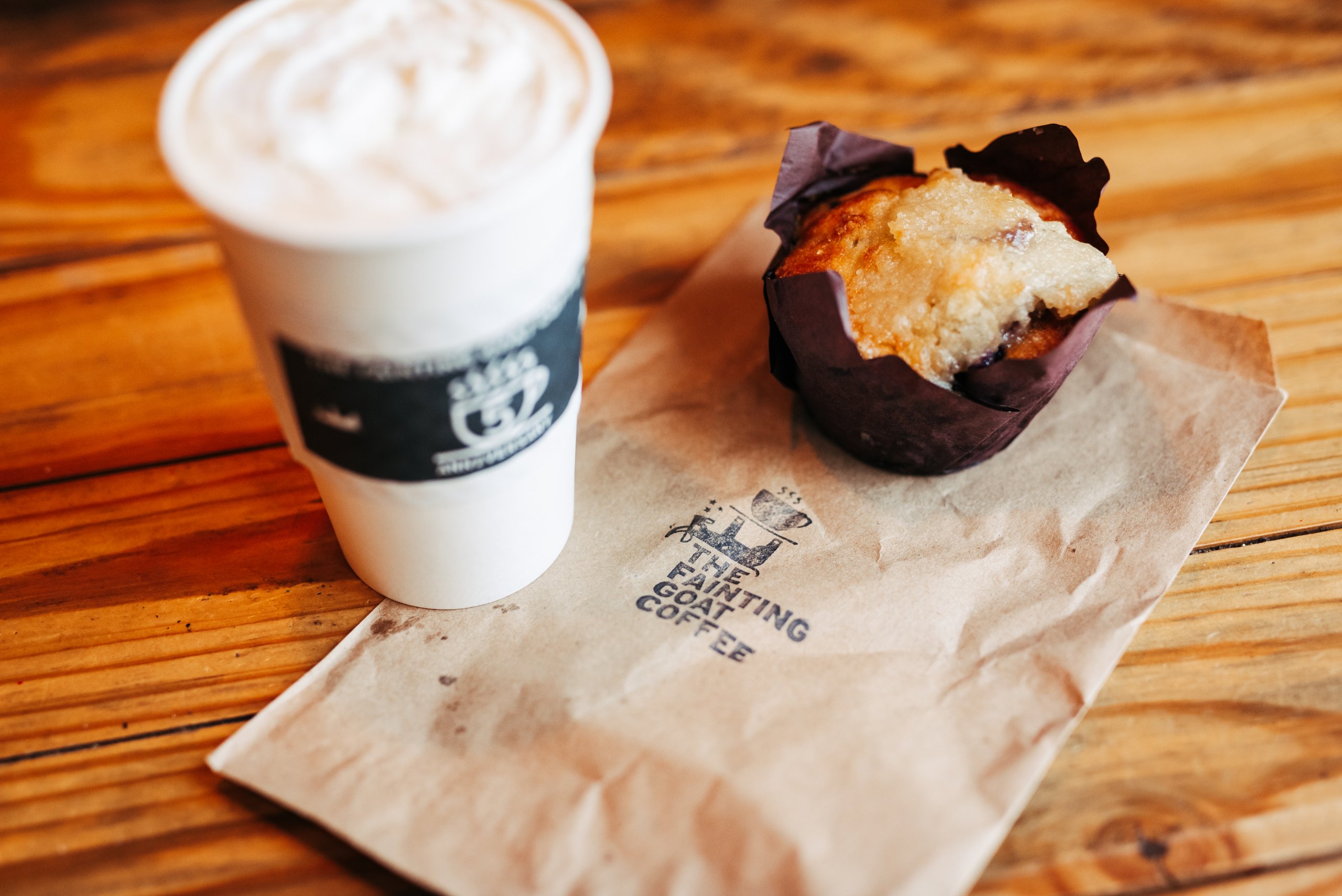 Spring Hill A steaming cup of coffee and a blueberry muffin on a wooden table in Williamson County, Tennessee.