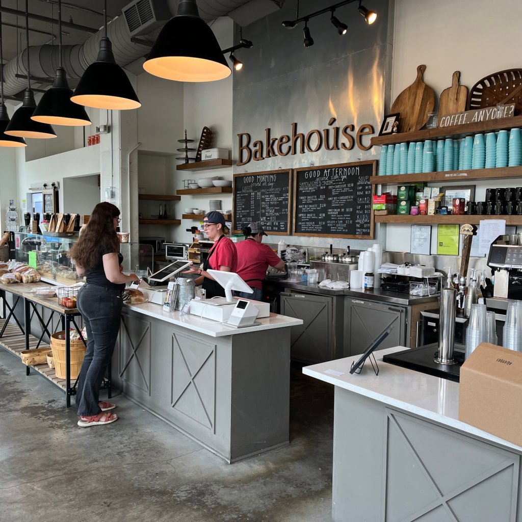 Three people work behind the counter at a modern bakery and coffee shop in Williamson County, Tennessee.
