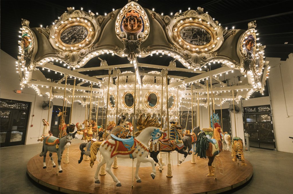 An ornate carousel with colorful horses and intricate gold details, illuminated by bright lights in Williamson County, Tennessee.