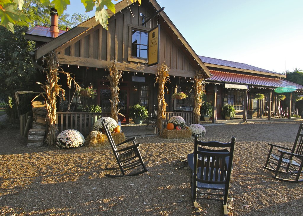 Rustic wooden cabin with rocking chairs, pumpkins, and fall decorations on a gravel path in Williamson County, Tennessee.