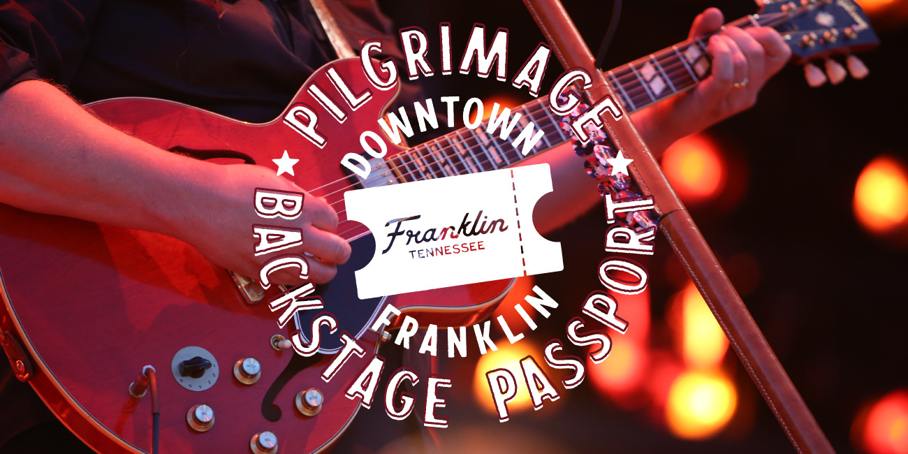 A musician plays a red electric guitar with a ticket graphic overlaying the strings in Williamson County, Tennessee.