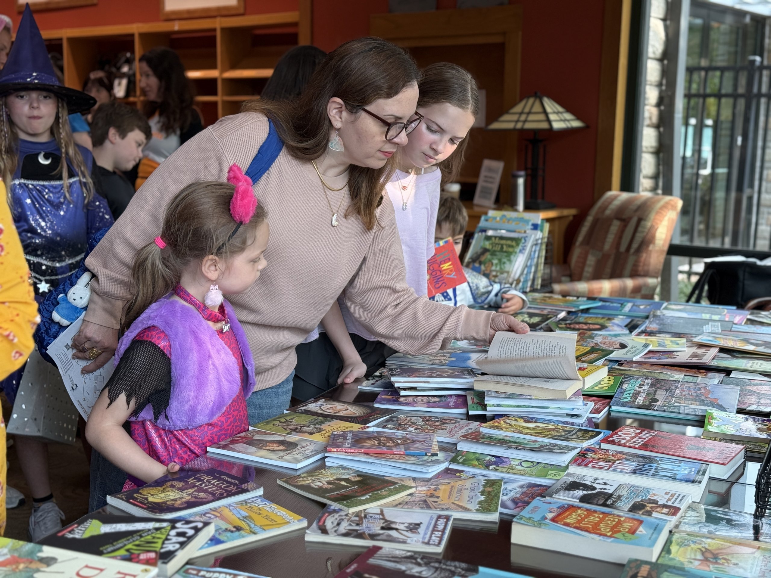 Friends Booktacular A mother and daughter browse a table of colorful children's books at a Halloween-themed event in Williamson County, Tennessee.