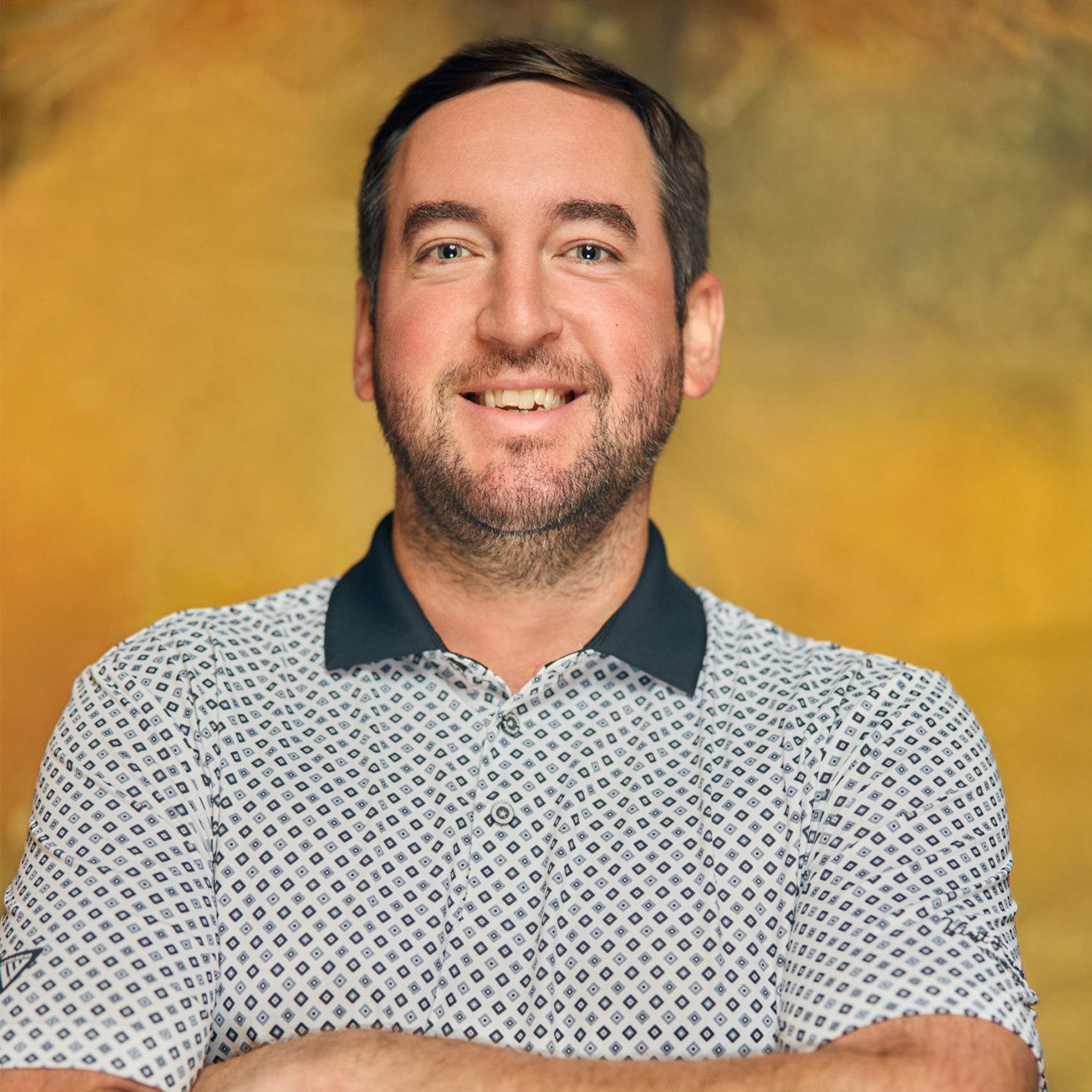 Meet The Team A smiling man with short brown hair and a beard wearing a patterned polo shirt in Williamson County, Tennessee.
