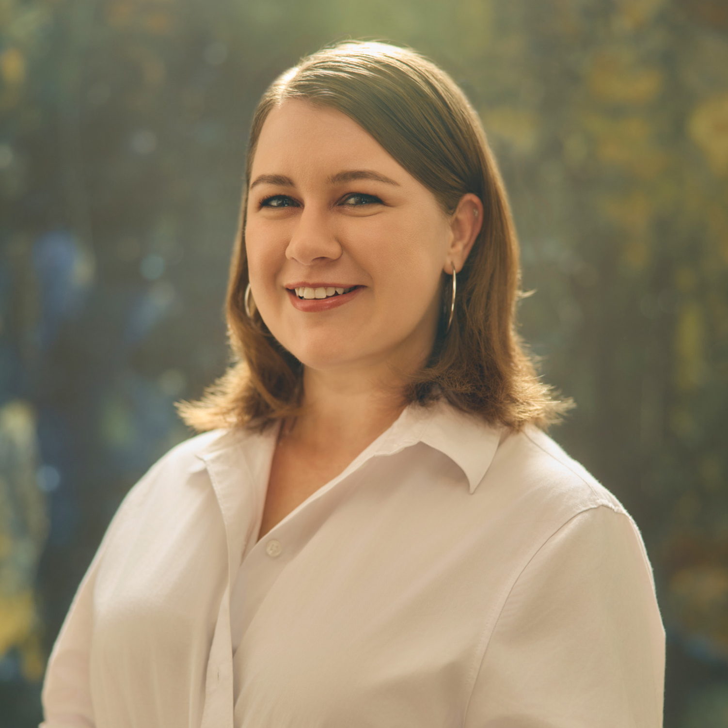 Meet The Team A smiling woman with shoulder-length brown hair wearing a white button-up shirt in Williamson County, Tennessee.