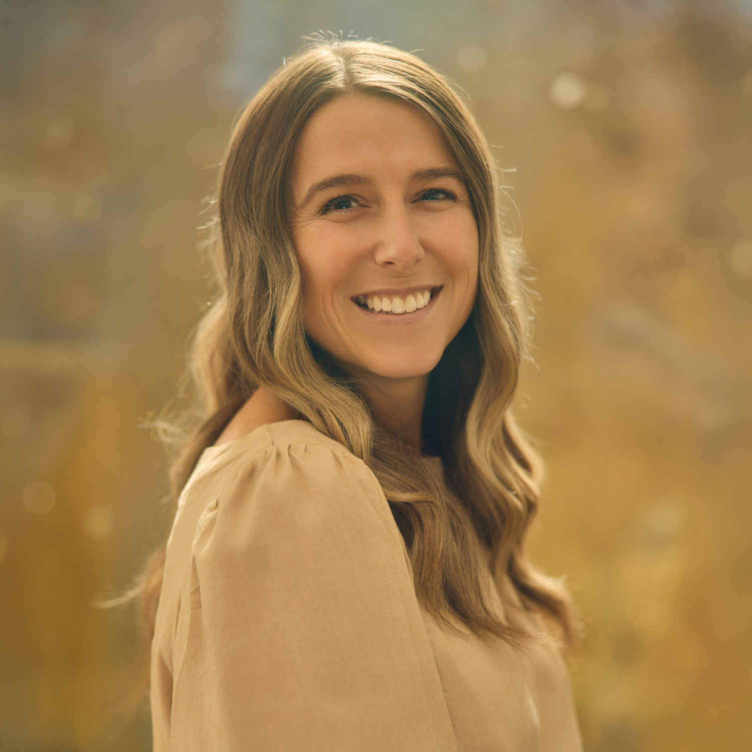 Meet The Team A smiling woman with long, wavy brown hair wearing a beige blouse in Williamson County, Tennessee.