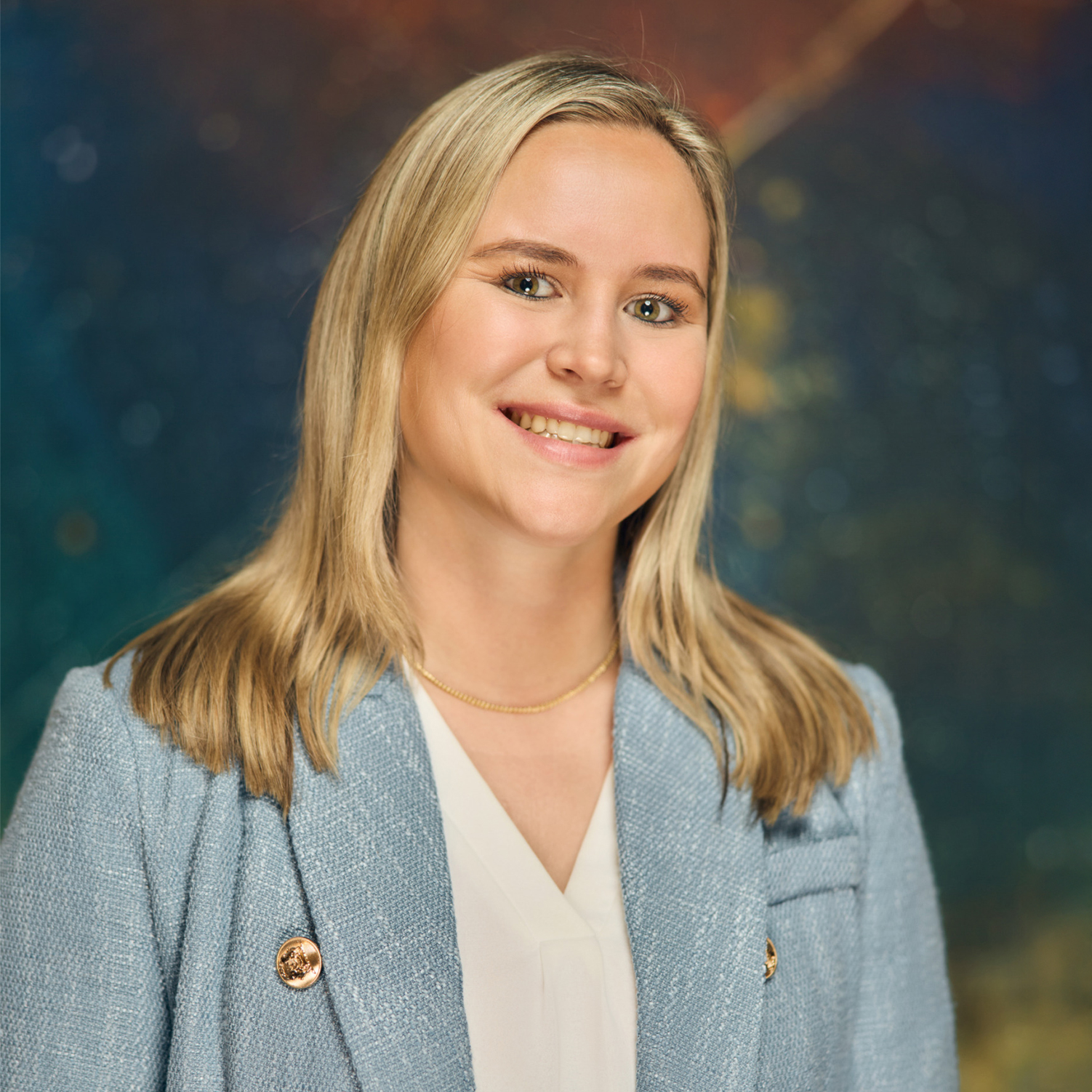 Meet The Team A smiling young woman with blonde hair wearing a light blue blazer and white shirt in Williamson County, Tennessee.