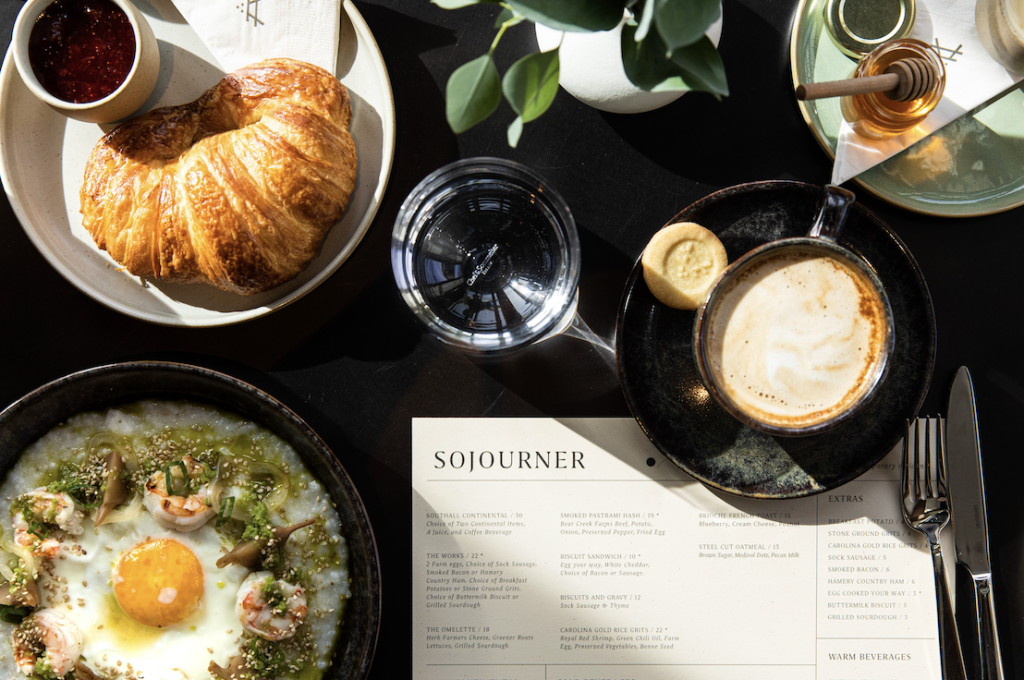 A breakfast spread featuring a croissant, bowl of shrimp and grits, and a cup of coffee in Williamson County, Tennessee.