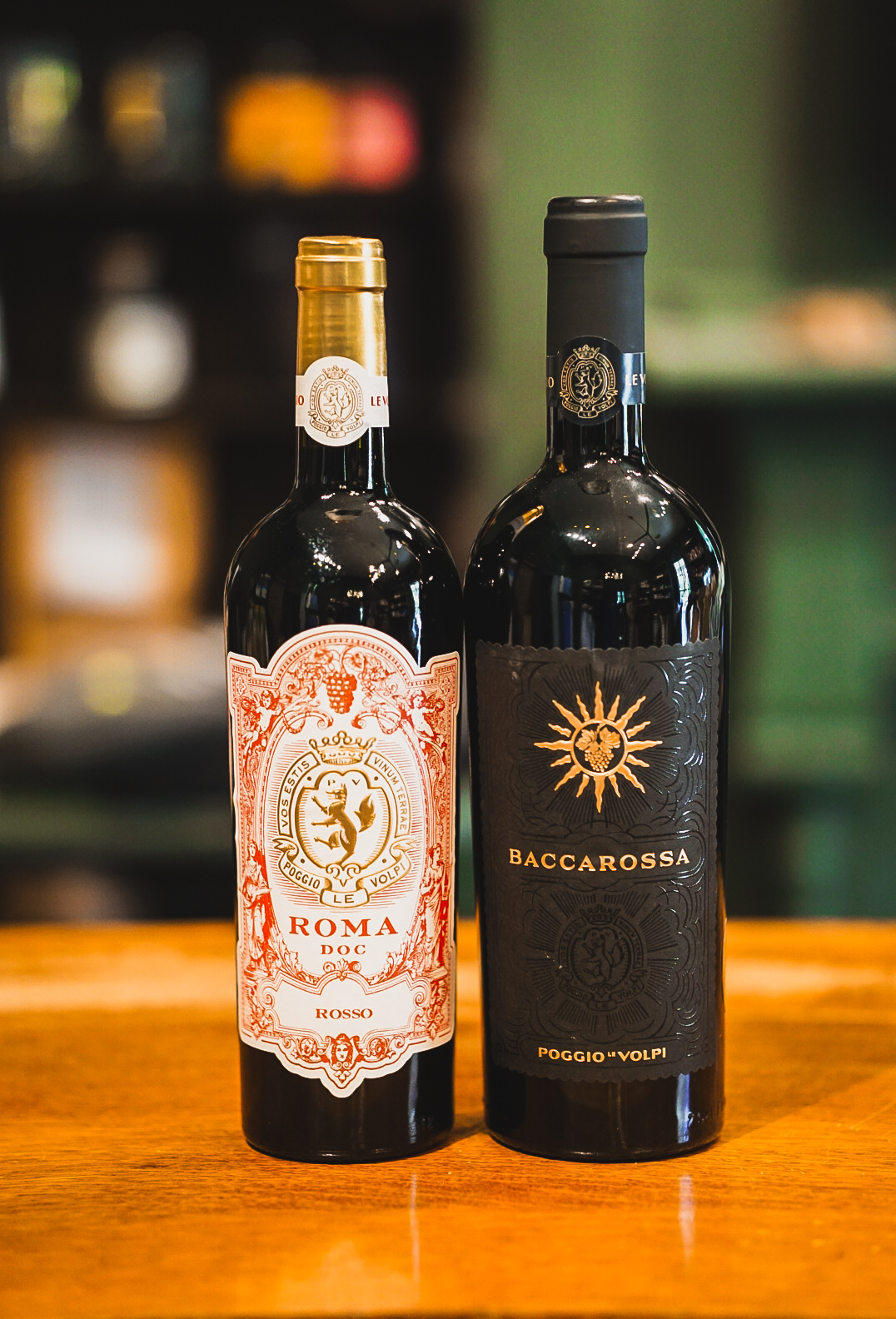 Meet the Producer - Daniele Girolami Two elegant wine bottles, one with a golden label and the other with a black label, stand side by side in Williamson County, Tennessee.