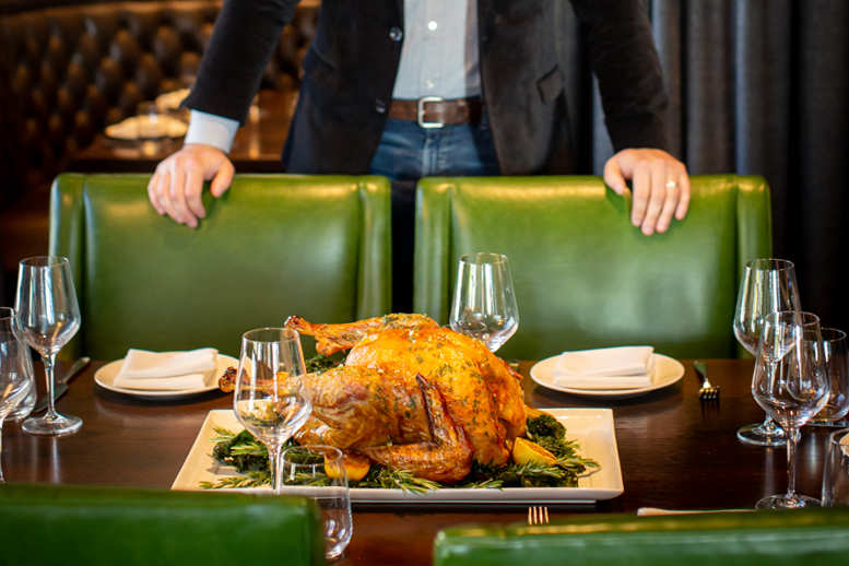A man stands behind a table set for a formal dinner with a roasted turkey as the centerpiece in Williamson County, Tennessee.