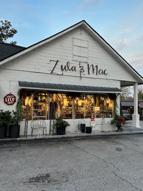A quaint white barn-style shop with festive decorations and a sign reading 'Zula & Mac' in Williamson County, Tennessee.