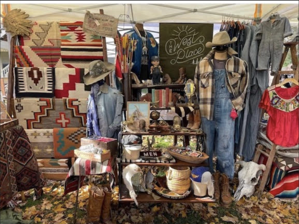 A colorful outdoor market stall with vintage Western-style clothing and accessories in Williamson County, Tennessee.