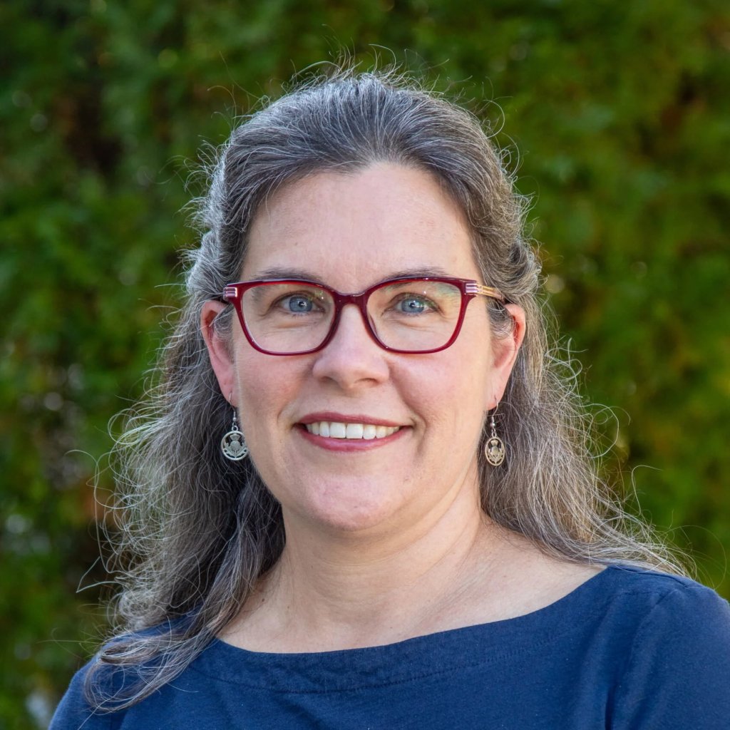Betsy Farquhar | Book Signing A smiling woman with gray hair and glasses wearing a blue shirt outdoors in Williamson County, Tennessee.