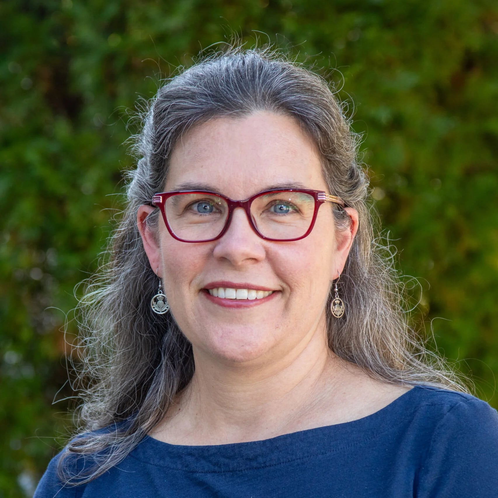 Betsy Farquhar | Book Signing A smiling woman with gray hair and glasses wearing a blue shirt outdoors in Williamson County, Tennessee.