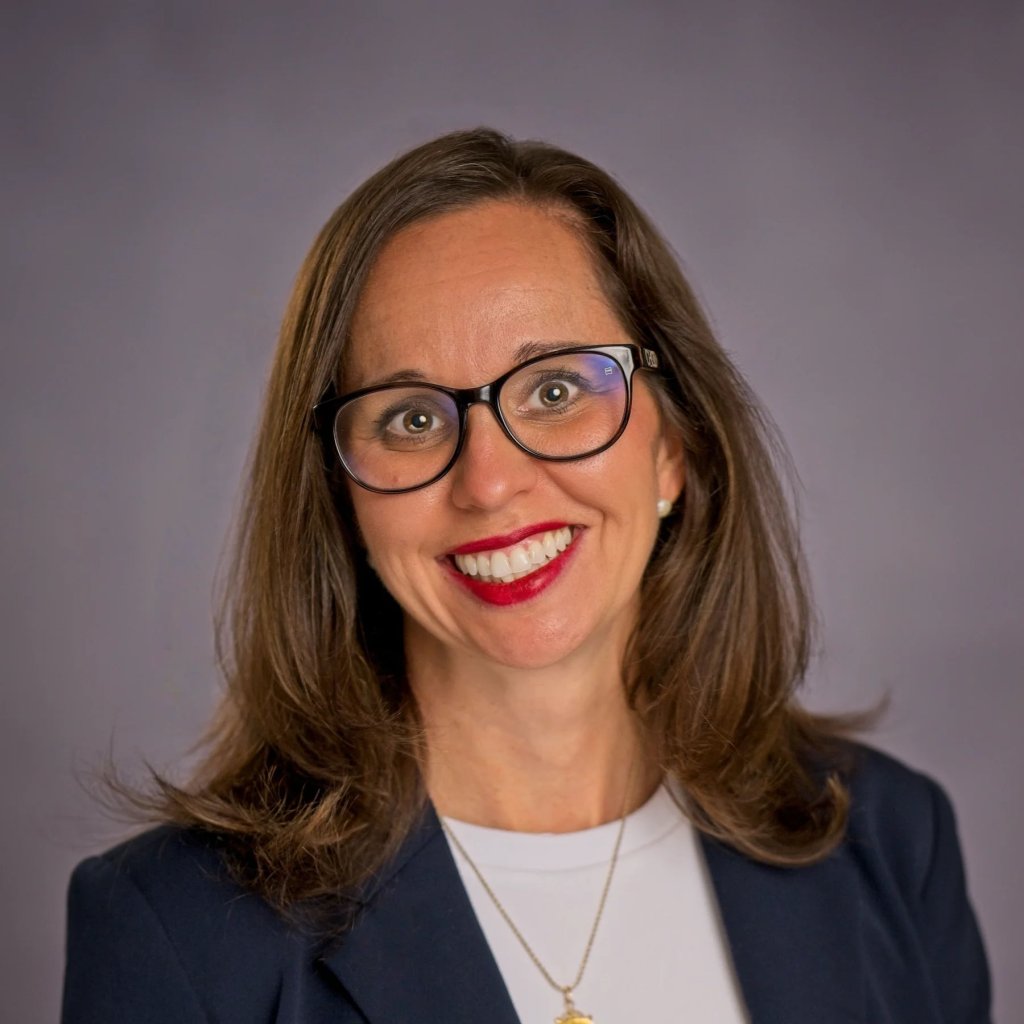 Alisha Erickson | Book Signing A smiling woman with glasses and red lipstick wearing a navy blazer and white shirt in Williamson County, Tennessee.