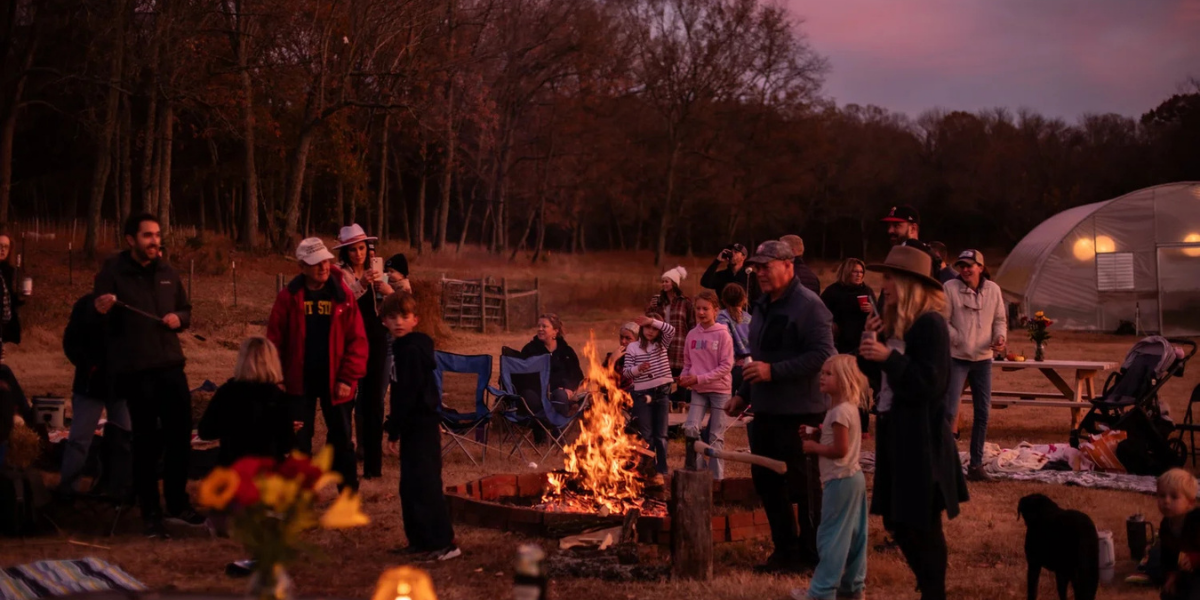 Fall Family Bonfire A group of people gather around a campfire in a wooded area at dusk in Williamson County, Tennessee.