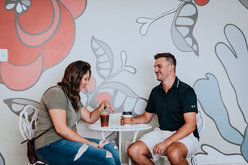 Cafes & Bars A couple enjoys iced coffee at a small table against a floral mural in Williamson County, Tennessee.