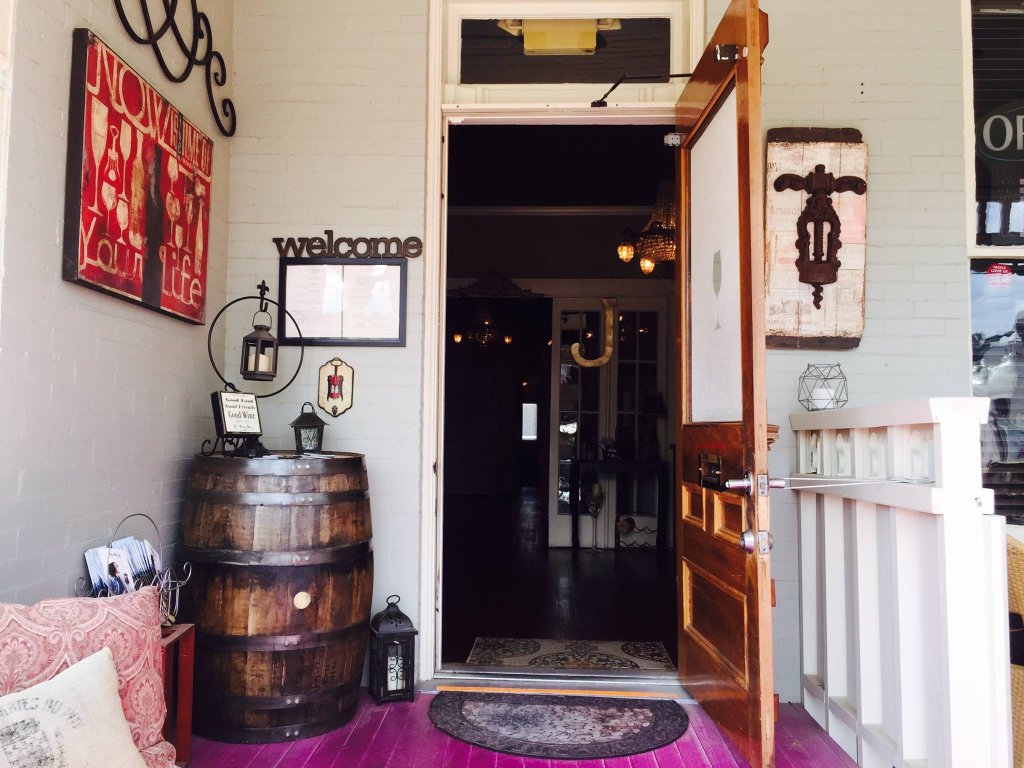 Cafes & Bars A charming entrance with a wooden door, wine barrel, and colorful wall art in Williamson County, Tennessee.