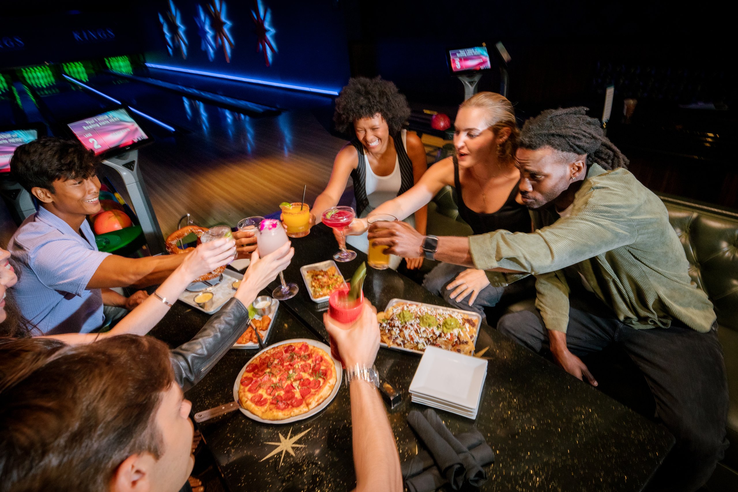 A group of friends enjoys a meal and drinks together at a bowling alley in Williamson County, Tennessee.