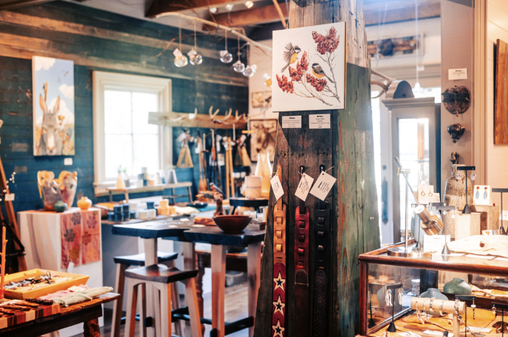 A rustic art gallery with wooden walls, displaying paintings, jewelry, and decorative items in Williamson County, Tennessee.