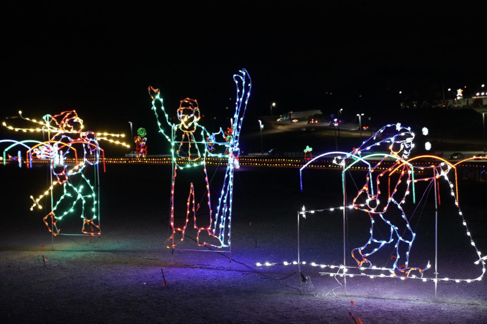 Celebrating Christmas in Franklin, Tennessee: A Guide to Local Holiday Traditions Four illuminated wire sculptures of skiers in various poses, set against a dark background in Williamson County, Tennessee.