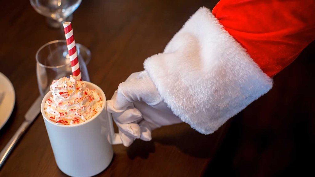 Celebrating Christmas in Franklin, Tennessee: A Guide to Local Holiday Traditions Santa Claus offers a mug of peppermint hot chocolate with whipped cream and a candy cane straw in Williamson County, Tennessee.