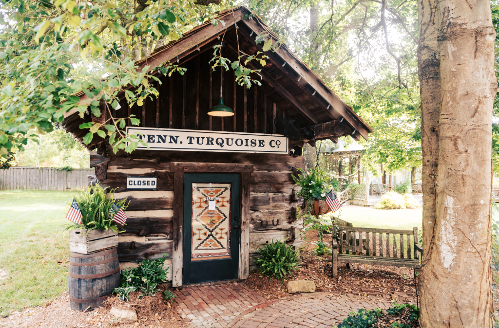 A rustic wooden cabin with a sign reading 'Tenn. Turquoise Co.' and a closed door in Williamson County, Tennessee.