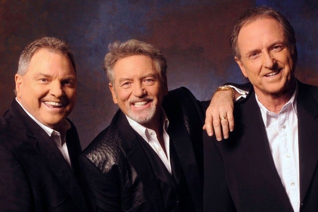Three smiling men in black suits pose together for a group photo in Williamson County, Tennessee.