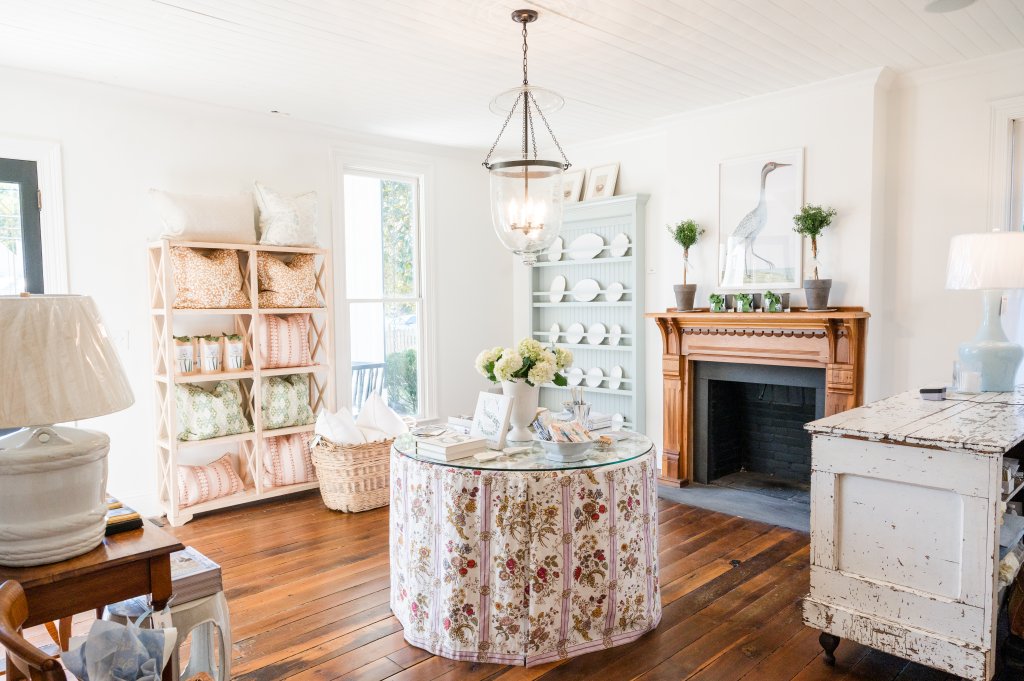 A cozy, rustic living room with a floral tablecloth, fireplace, and decorative shelves in Williamson County, Tennessee.