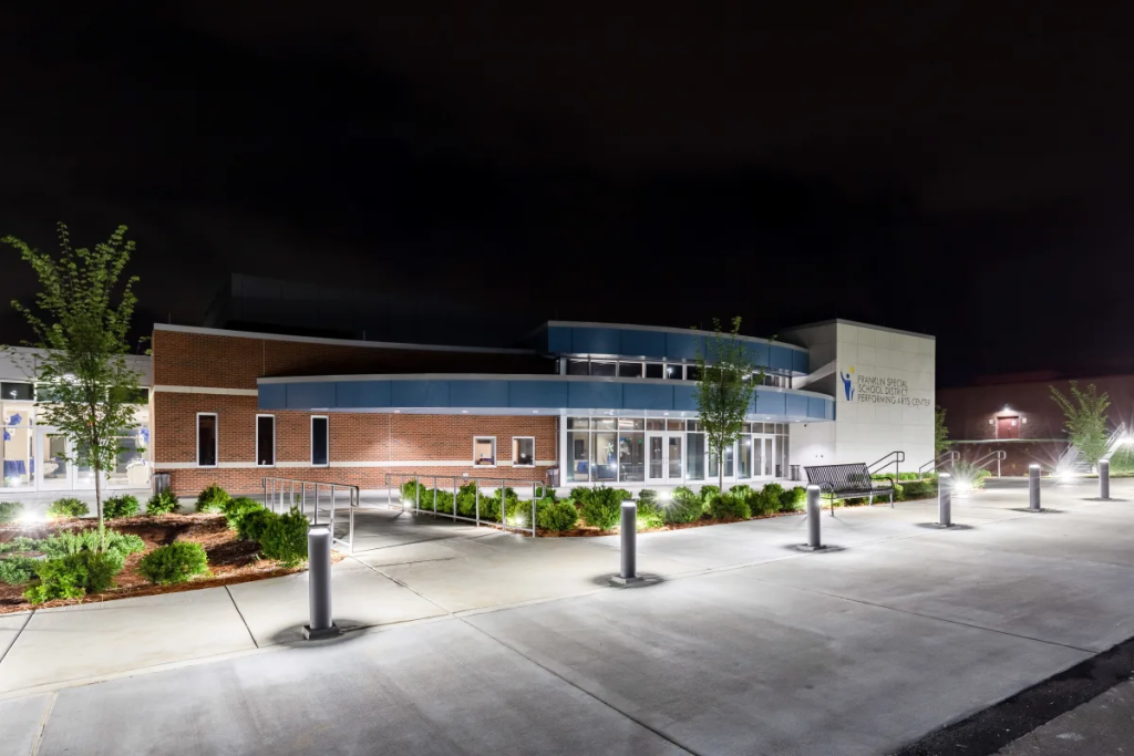 A modern, well-lit building with a curved facade and glass entrance at night in Williamson County, Tennessee.