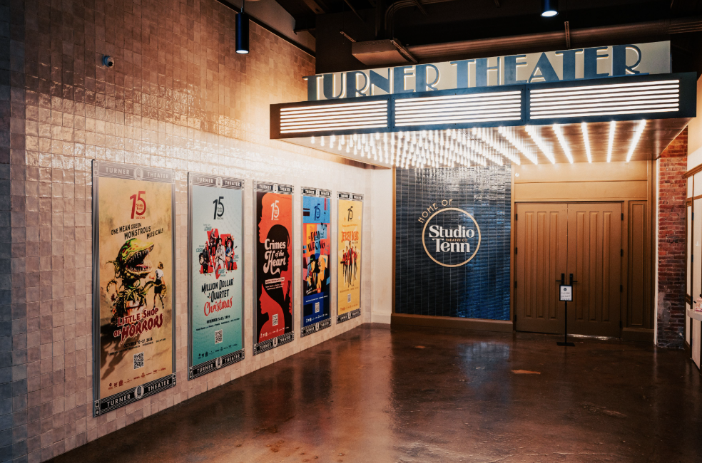 Vibrant movie posters line the walls of the Turner Theater lobby, illuminating the space with their colorful designs in Williamson County, Tennessee.