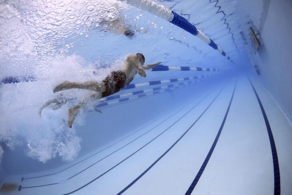 A swimmer propels through the water in a long, narrow indoor pool, surrounded by lane dividers in Williamson County, Tennessee.