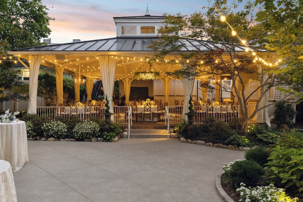 An elegant outdoor wedding reception under a beautifully lit gazebo surrounded by lush gardens and trees in Williamson County, Tennessee.