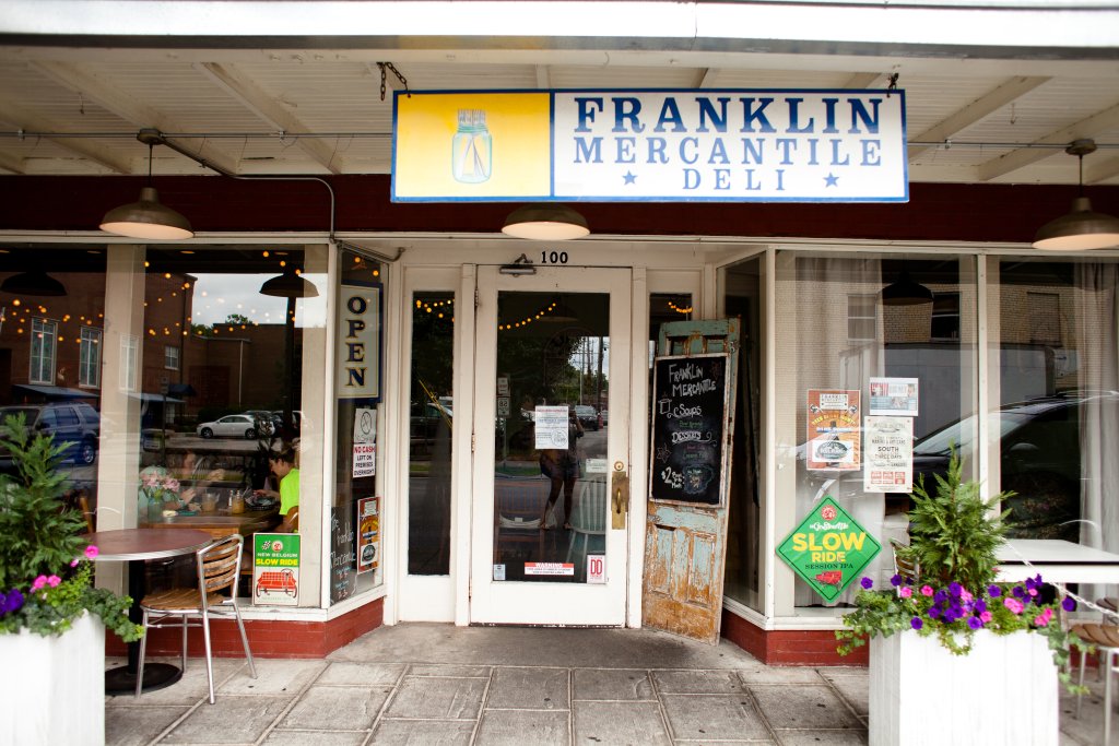 Franklin Mercantile Deli, a quaint storefront with a blue and yellow sign, invites patrons to enjoy a variety of sandwiches and salads in Williamson County, Tennessee.