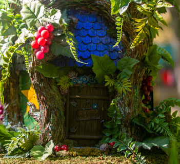 Tennessee Renaissance Festival A whimsical treehouse door, adorned with vibrant red berries and lush greenery, invites visitors to enter a magical forest realm in Williamson County, Tennessee.