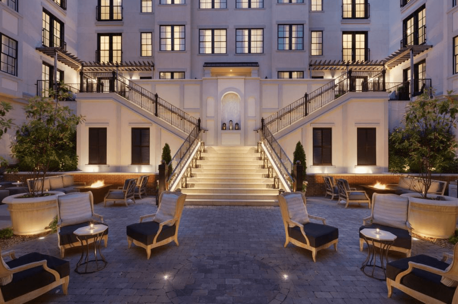 An elegant outdoor courtyard with a grand staircase leading to a modern building, surrounded by comfortable seating areas and lush greenery in Williamson County, Tennessee.